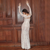Full view of a bohemian-style formal lace gown with sheer sleeves.